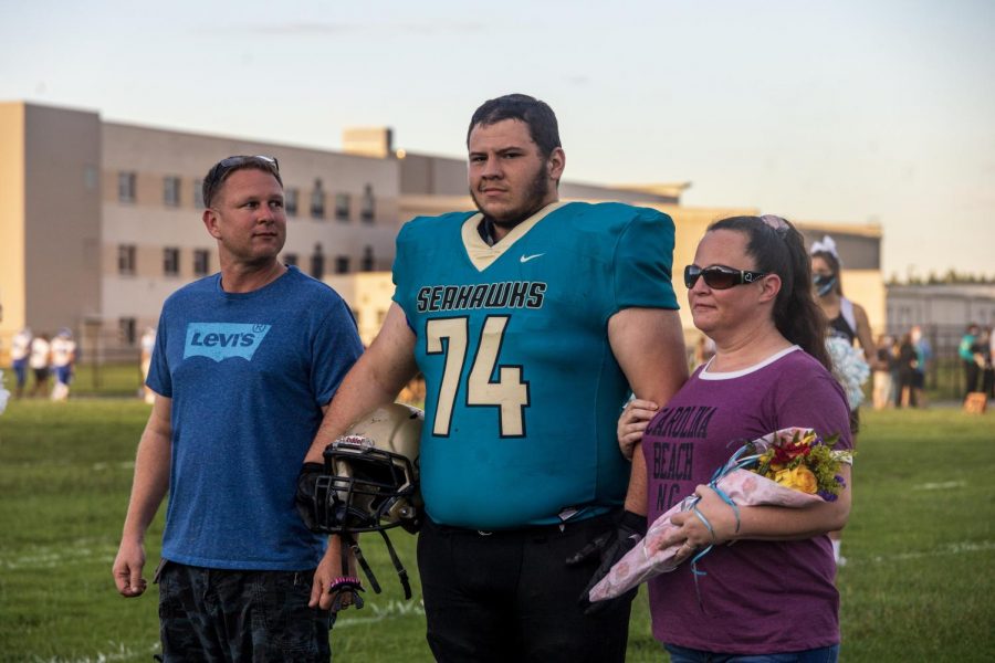 Walking across the field one final time on his senior night with  his mom (Kayla Clark) and his dad (Byron Clark).