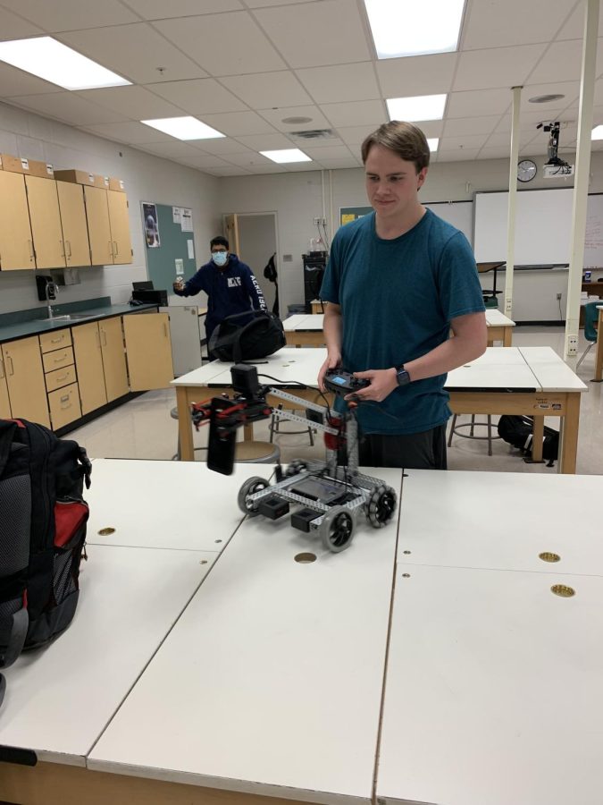 Senior Ty Cockerham (right) masterfully manages the robotics clubs grasping robot, with senior Vedannt Sarker(left) providing the carton. In past years, Ty has competed in VEX robotics competitions. He says, We have also worked on creating a robot for the robotics trick-or-treats around the track.