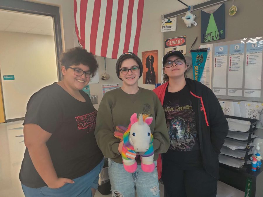Alex runs the diversity club along with the help of Kayla and Tyler. Alex is holding the unicorn passed around during tea time On the left is Kayla Rodriguez, on the right is Tyler Hess and in the middle is Alex Rhein.