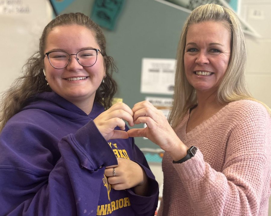 Ms.+Hall+and+sophomore+Megan+Olsen+make+a+heart+with+their+hands.