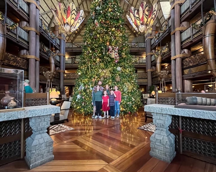 Naomi and Eliza Lammers with their family in front of the Christmas tree at Disneys Animal Kingdom Lodge.
