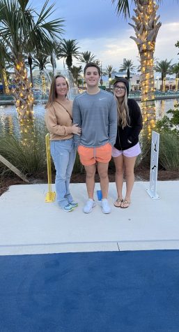 Pictured is Hanna, her mom, and her brother standing in front of shops at the beach.