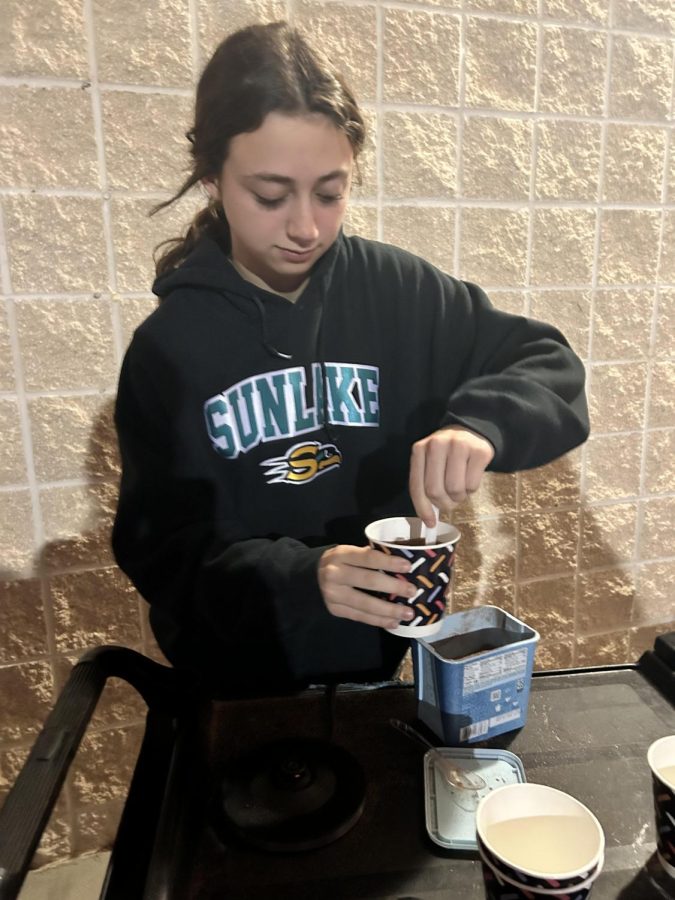 Genevieve Garcia pouring in some hot chocolate mix during the hot chocolate station before break.