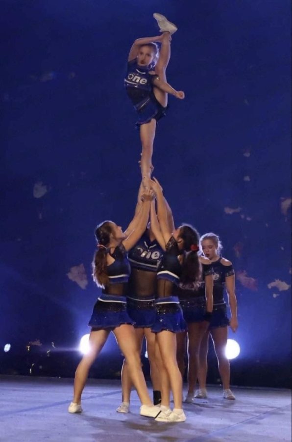 Anastasia Rakoch (Sophomore) On the right, setting a base for her flyer in a stunt being performed at a competition