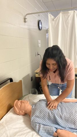 Kimberly Phillips practicing CPR on a mannequin.