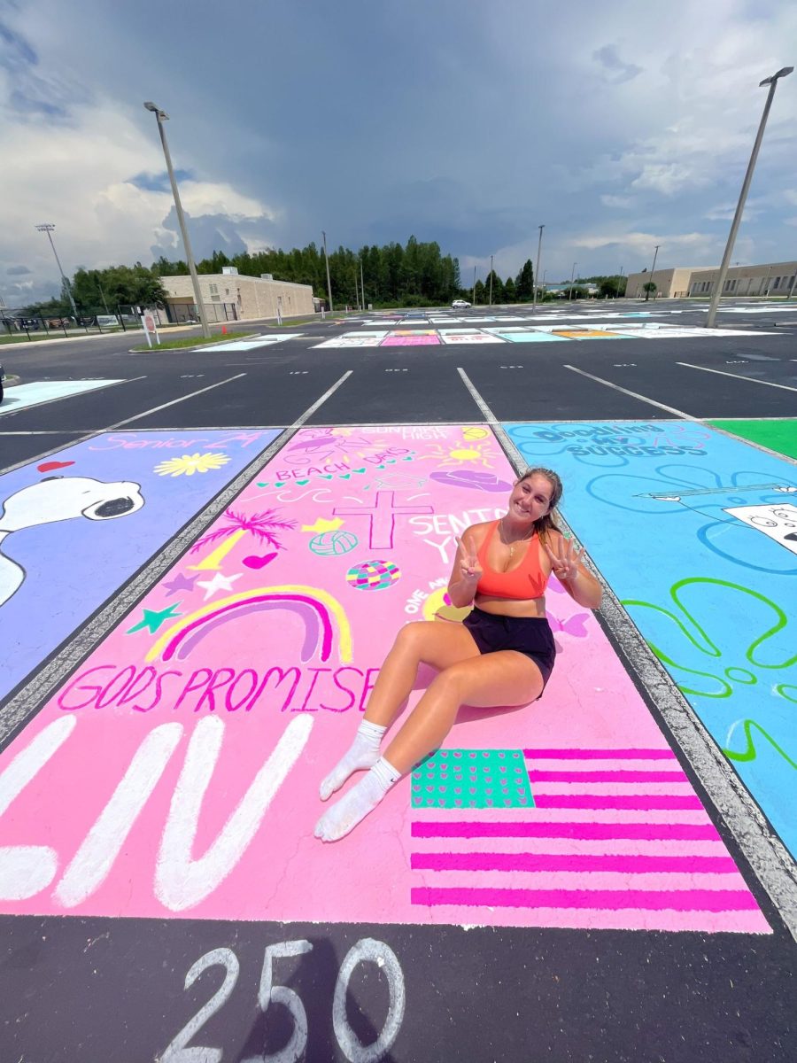 Senior Olivia Moore posing with her newly painted parking spot for the new school year.