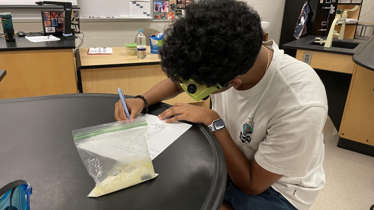 Sophomore Manikandan Venkata working on his first lab in Ms. Latimores Chemistry Honors class. I took note of how reactants are reacting to one another in the baggie, Manikandan said. 