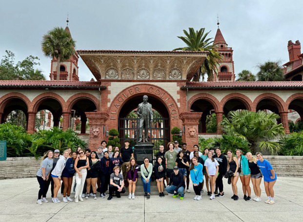 All+of+the+students+on+the+trip+posed+around+a+statue+under+an+arch+at+Flagler+College.