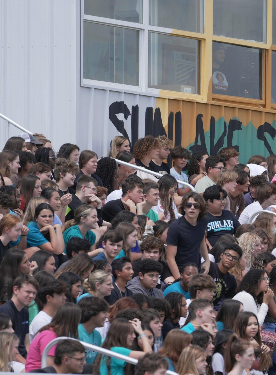 Noah Lowery in a crowd of Sunlake students enjoying the pep rally. He is watching the senior skit performance.