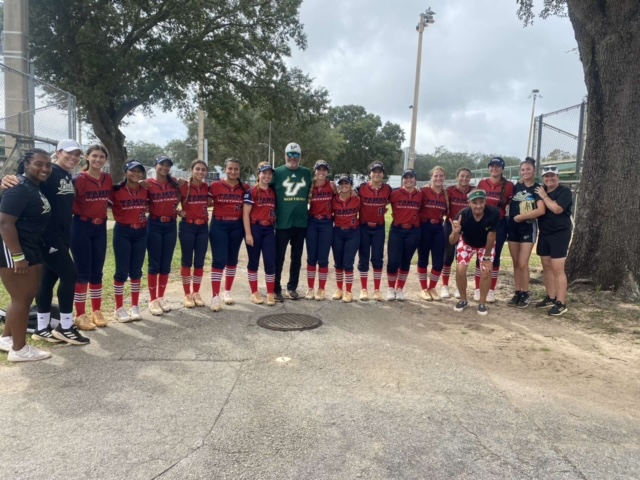 This is Analese with her travel softball team. They are with the USF coach at the USF camp. Analese is the the third person from the coach on the left.