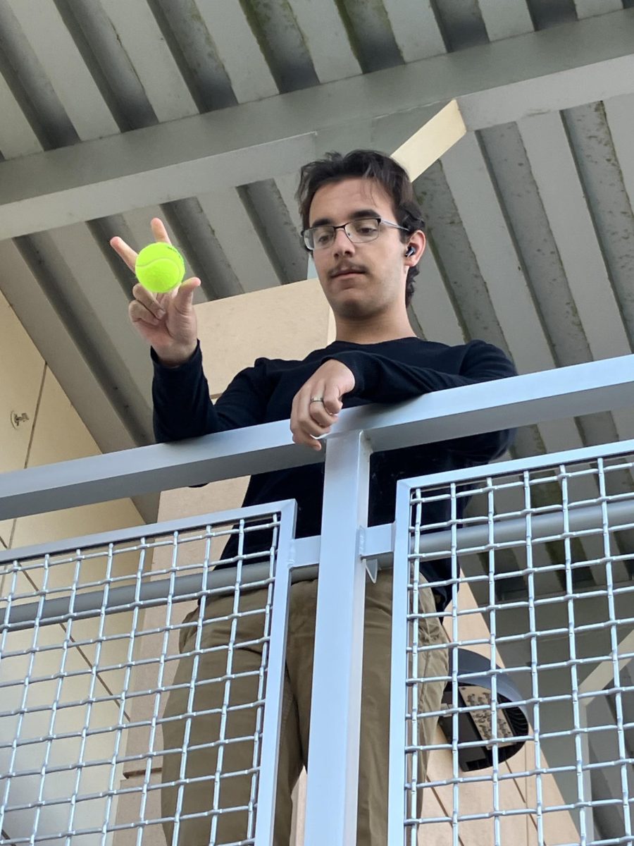 Junior Joseph Houk dropping a tennis ball off the second floor of building ten. As he dropped the ball, he said start so his lab partner to begin the timer. Getting accurate measurements is a challenging but rewarding experience!