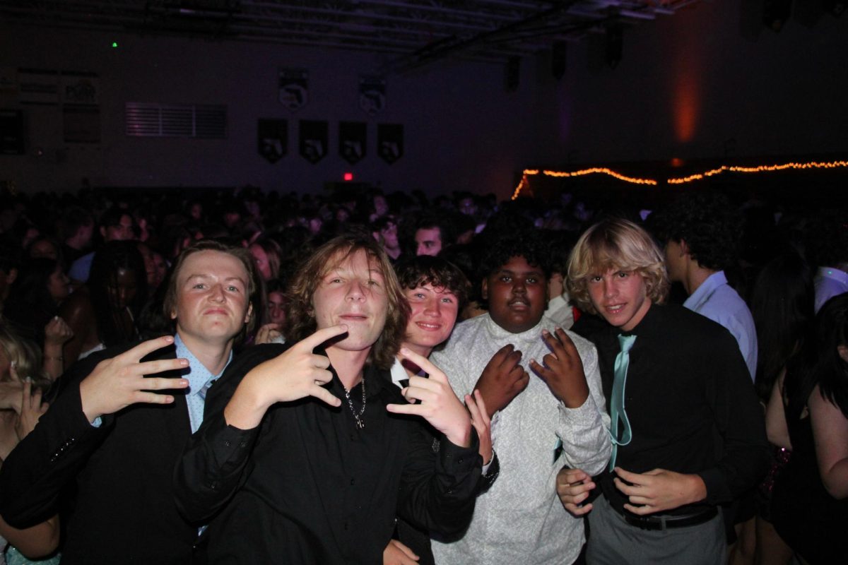 Sophomore Tate Carlson (one the right) poses with a group of friends. He is on the dance floor at Homecoming.