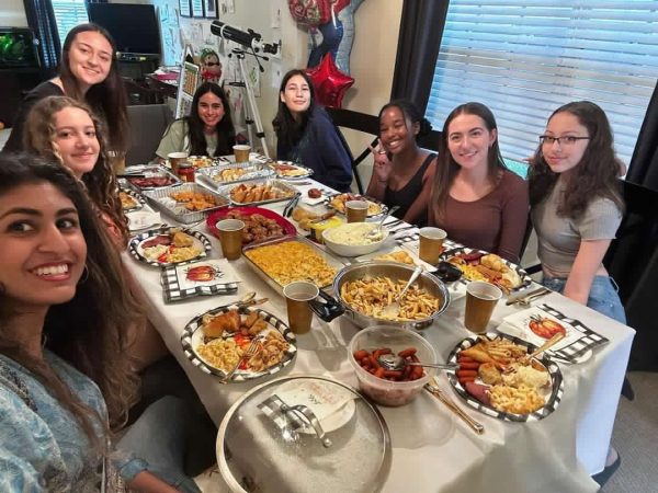 Samantha Mungai alongside her friends at the dinner table before eating their friendsgiving feast.