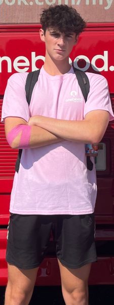 John Feeney posing outside a OneBlood bus. There was a number of buses at the blood drive, allowing many students to donate at once.