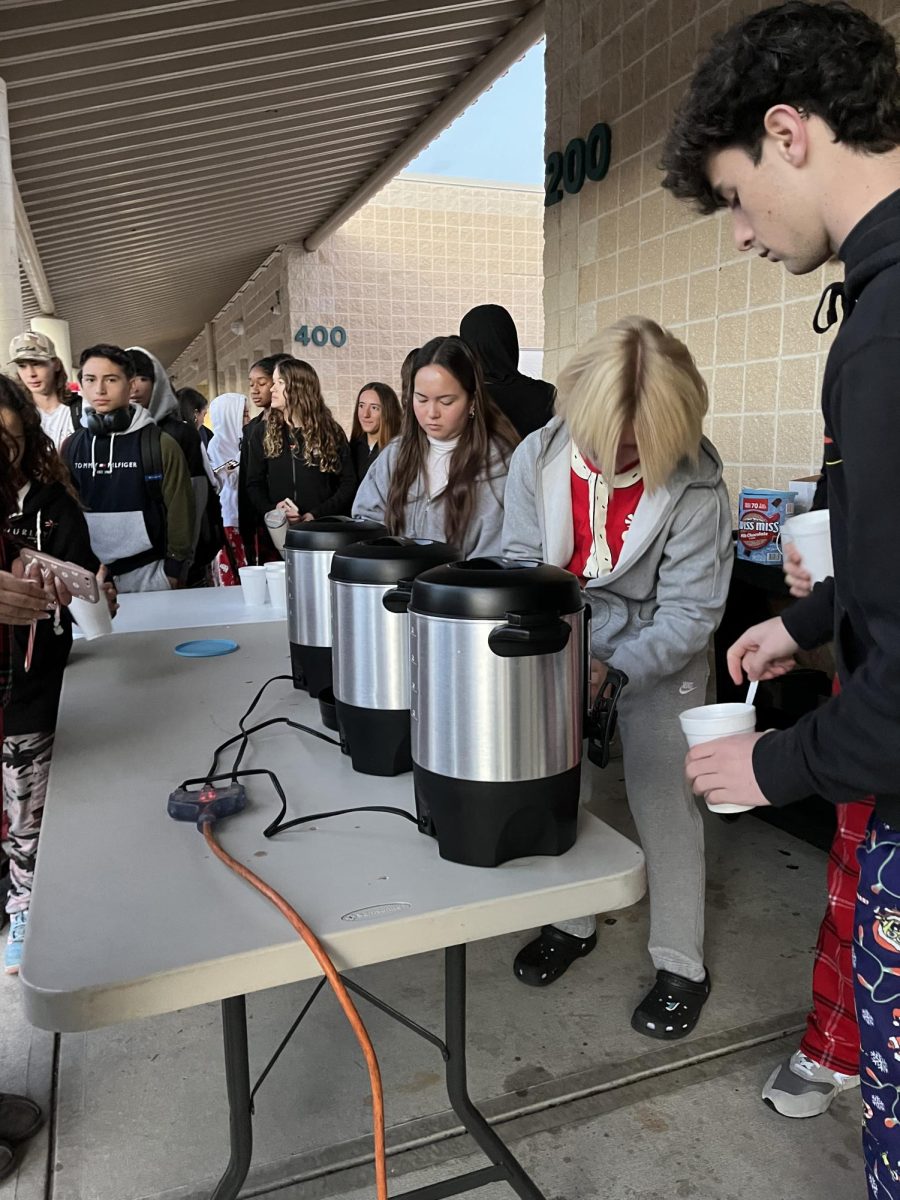 Members of student council handing out hot chocolate before school starts. Since it was a cold day, many students came to get a cup. Eric Travis said, “...normally people will get it after they are dropped off or when they get off their bus.”