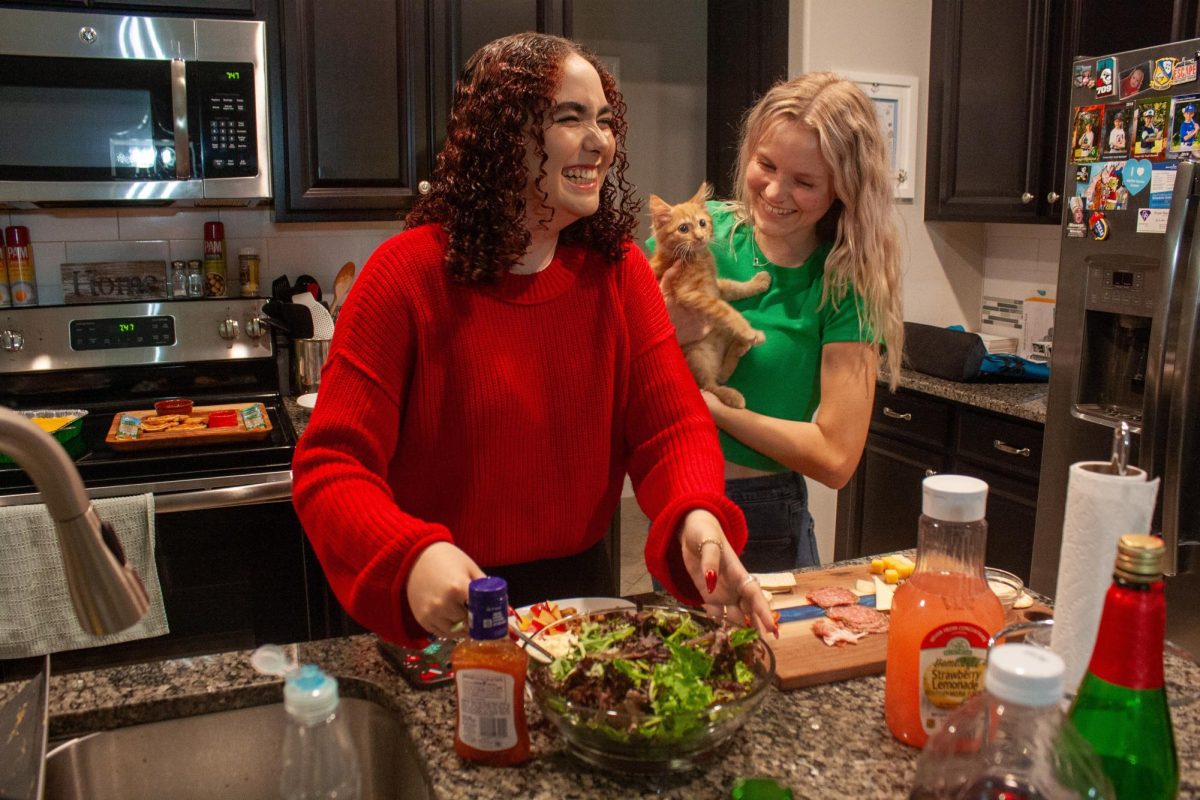 Seniors Remley Velde and Kaitlyn Schwartz preparing for their Friendsgiving. Remley is in the red sweater and Kaitlyn is in the green shirt. Remley stated, I love hosting Friendsgiving and celebrating with my close friends. 