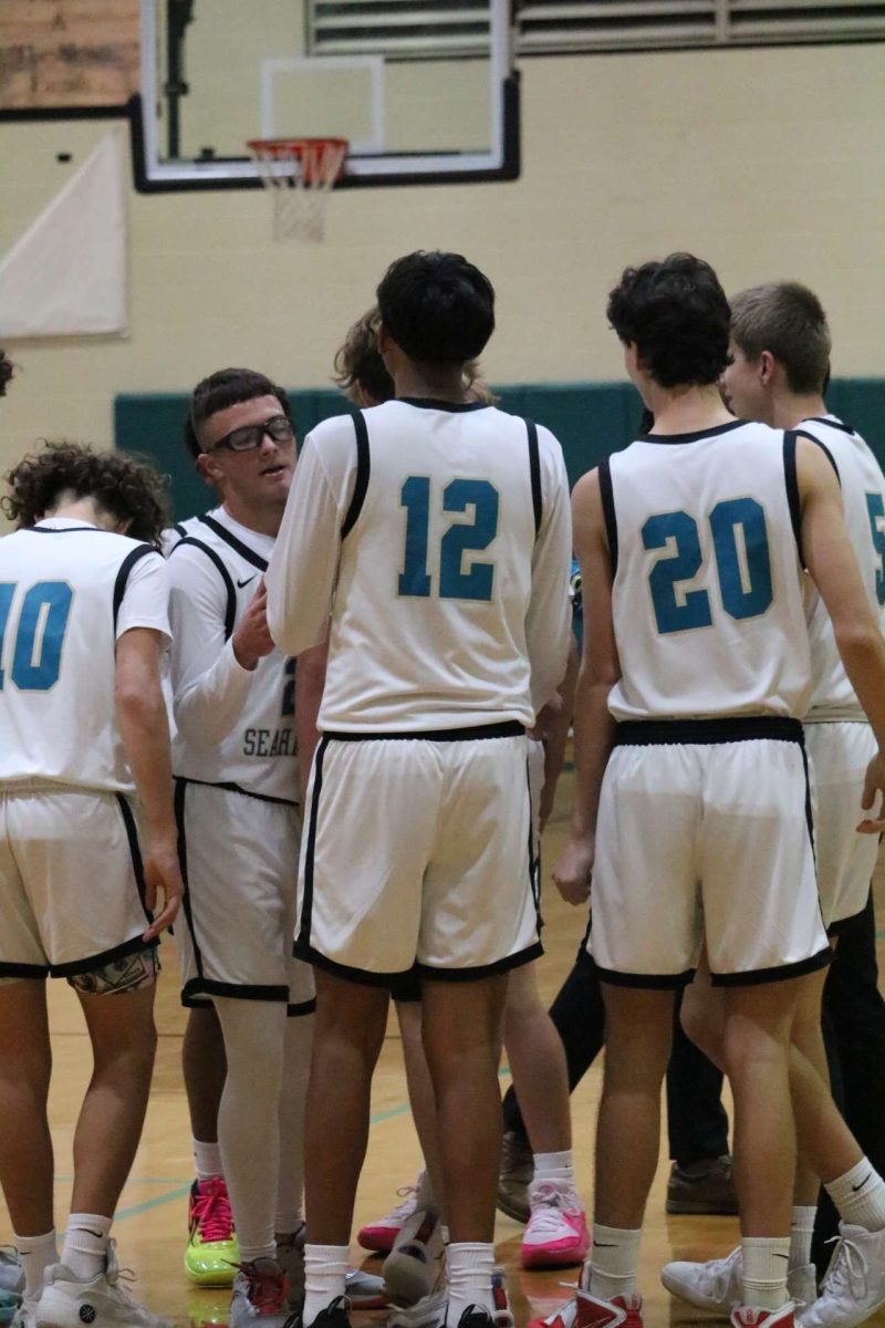 The Sunlake junior varsity boys basketball team in a huddle during a timeout.