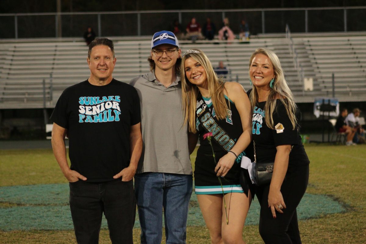 Senior Jillian Moore with her family during her cheer senior night.