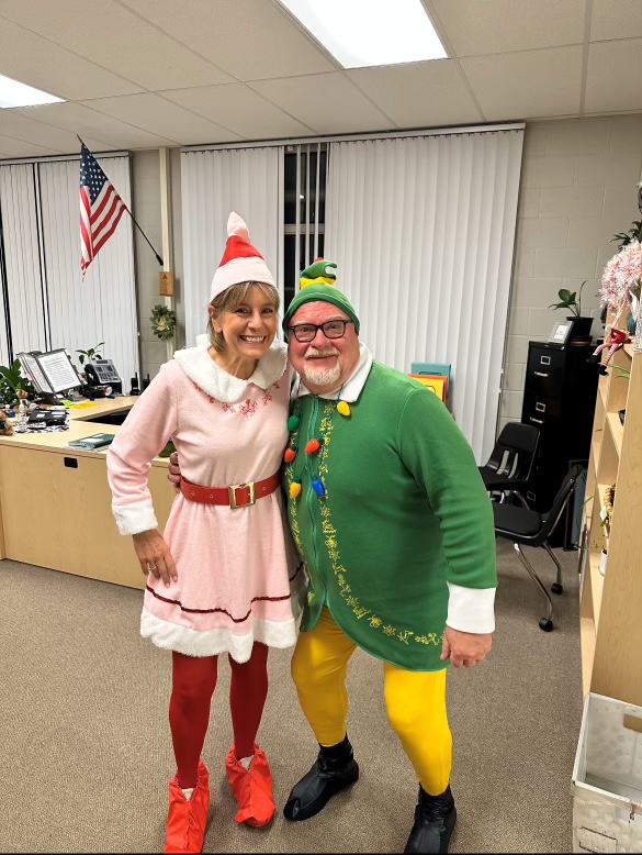 Mr. Elias and Mrs. Merlin dressed up as elves. They dressed up as elves for Christmas spirit week. The theme for Wednesday was dress up as your favorite holiday character.