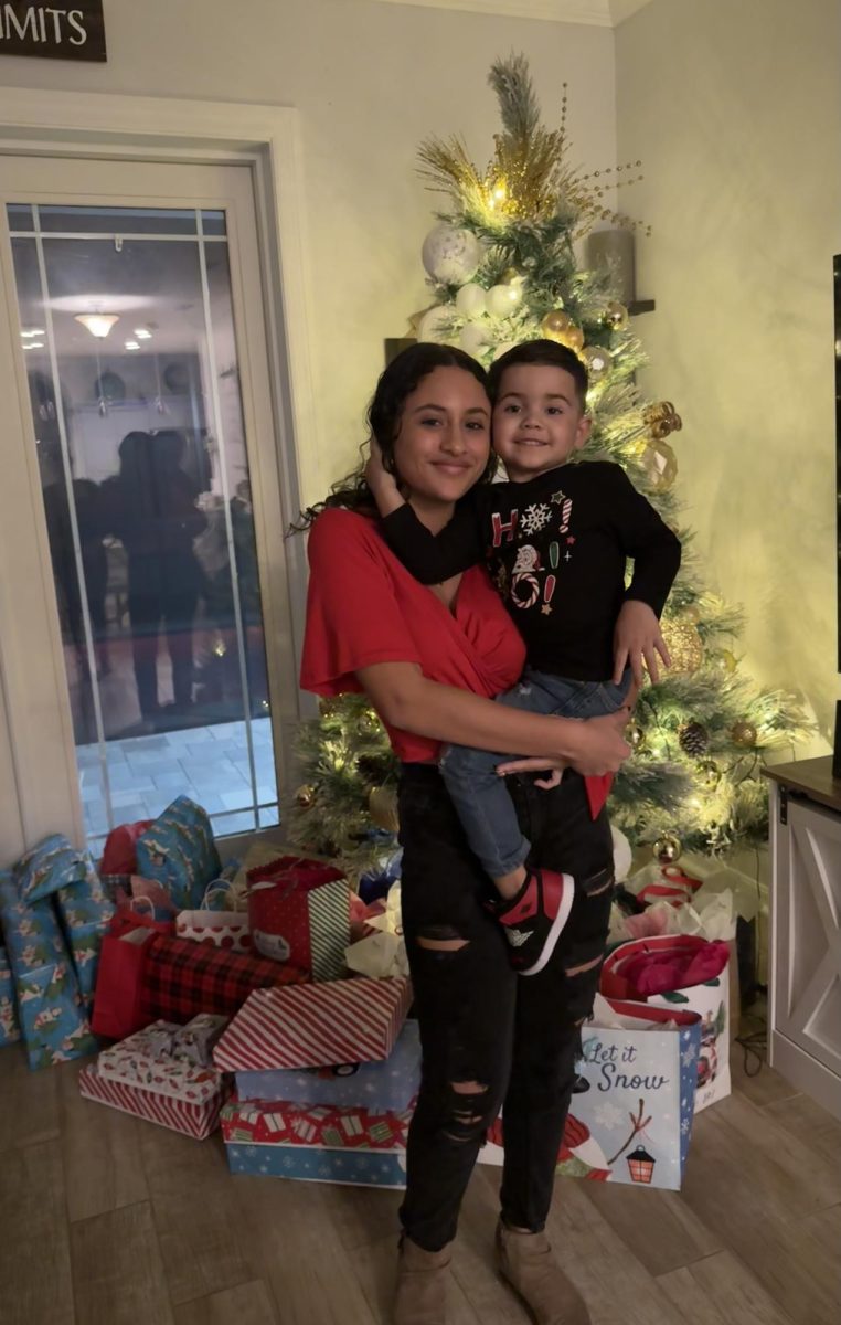 Heidimar Rivera holding her nephew during Christmas eve at her aunts house.