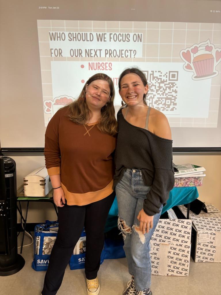 Juniors Emma Heiss (left) and Maggie Chauncy (right) pose for a photo after discussing future projects for upcoming meetings during a Random Acts of Kindness meeting.