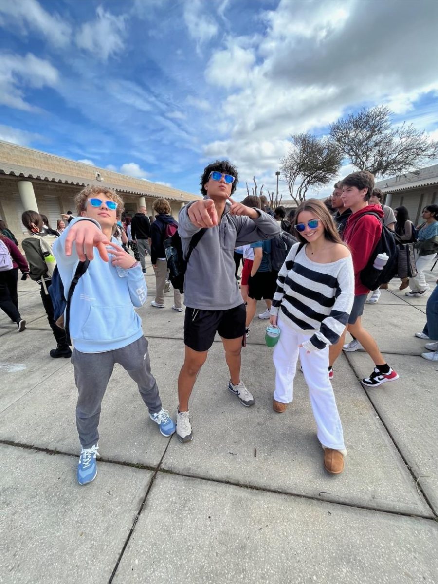Junior Sofia Perez (right) along with juniors Noah Sagnip (middle) and Mario Perez (left) posing for a picture in the Sunlake courtyard with glasses that were earned at a school assembly.
