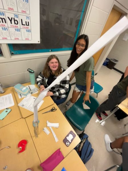 Angelina and her classmates participating in the AP Physics experiment. They are trying to achieve the tallest paper tower possible. They are having fun creating the tower while learning more about physics.