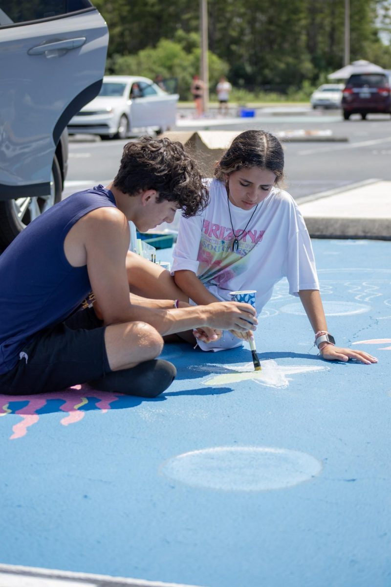 Alana and her boyfriend, Juan are seen in this photo. they are concentrated while painting. 