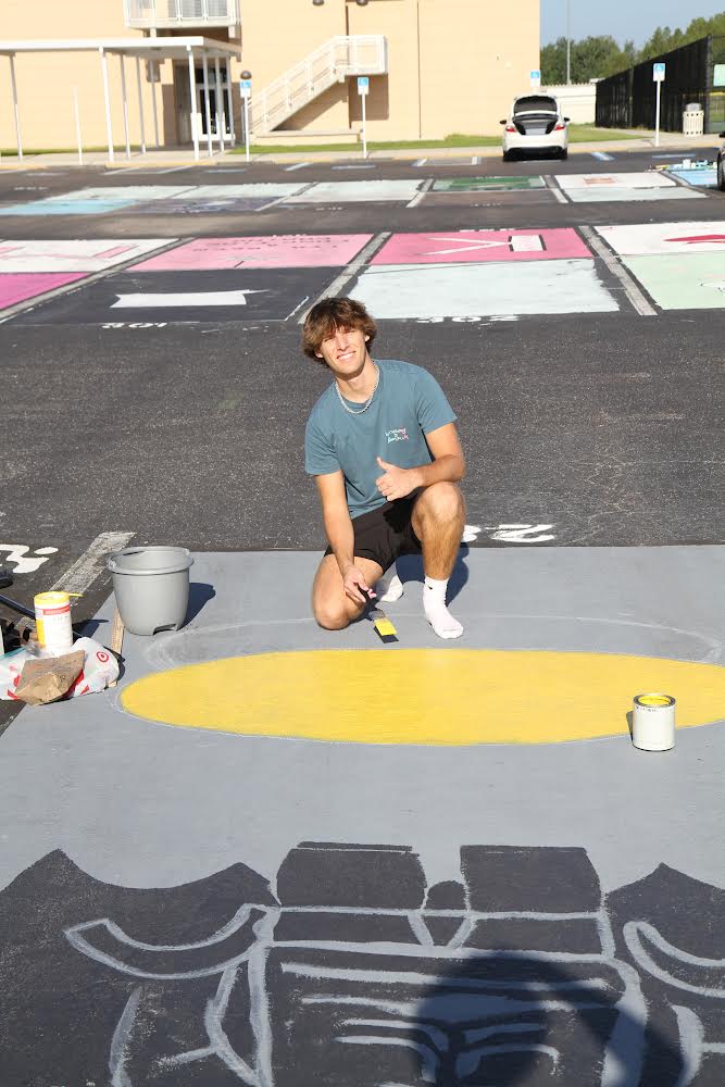 Landon posing for a picture while paintng his spot. He stated, "Its a fun experience to remember." He was painting his favorite part.