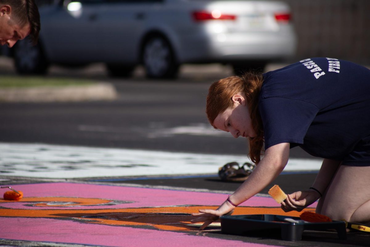  Senior, Caitlyn Wyne helping paint a parking spot for her friend that she carpools with. 