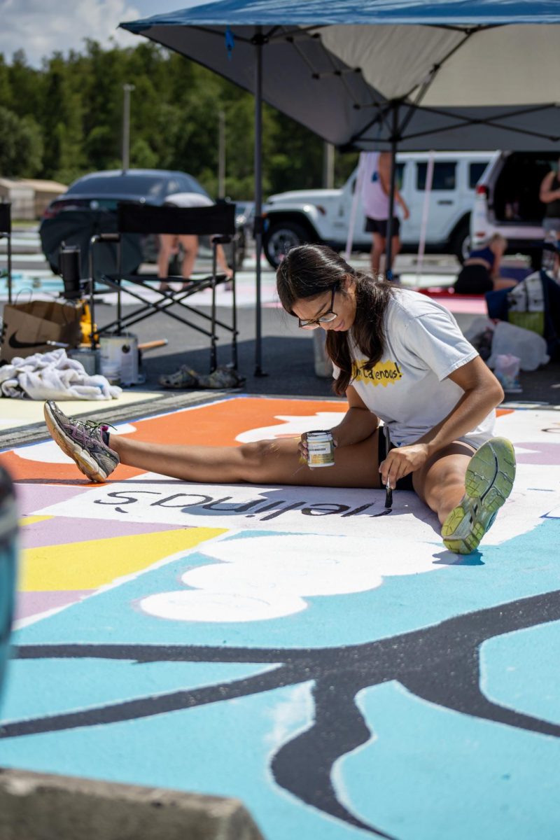 Senior, Angelina Gonzalez painting her parking spot in the student lot. 