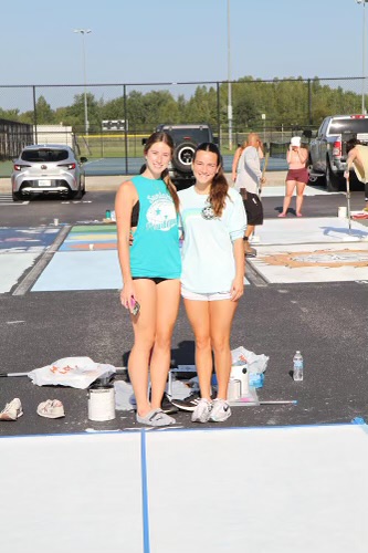 Senior, Sofia Perez is in the long sleeve shirt. This picture is taken while painting her senior spot with her friend, Emma Stephens. Sofia states, "I ended up loving the outcome of my parking spot, so it was all worth it."