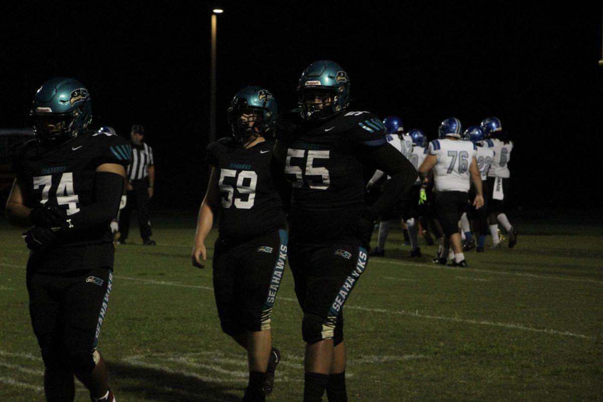 Christian Canarte, (55) on the right, a junior; under Friday night lights walking with his teammate excited to take this win home. 