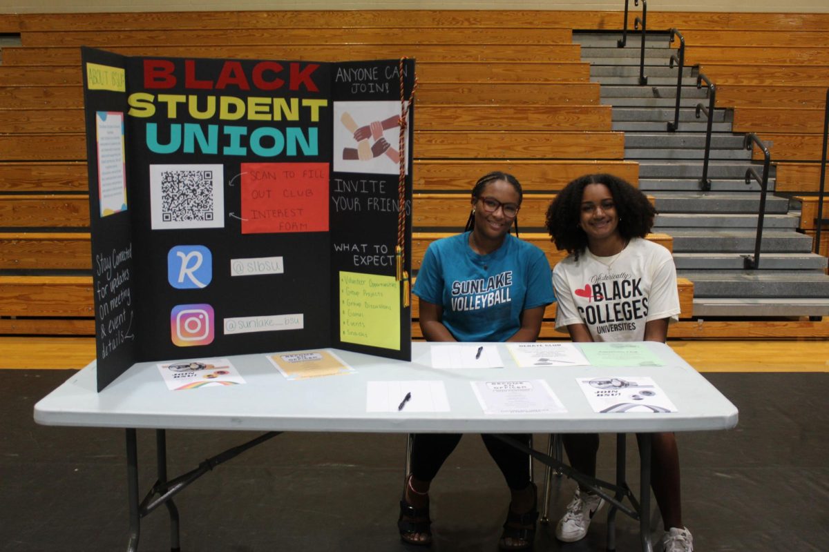 Taylor Mack (right) and Zayda Thomas (left) siting at their booth during freshmen orientation. The girls are recruiting fellow students to join the Black Student Union.