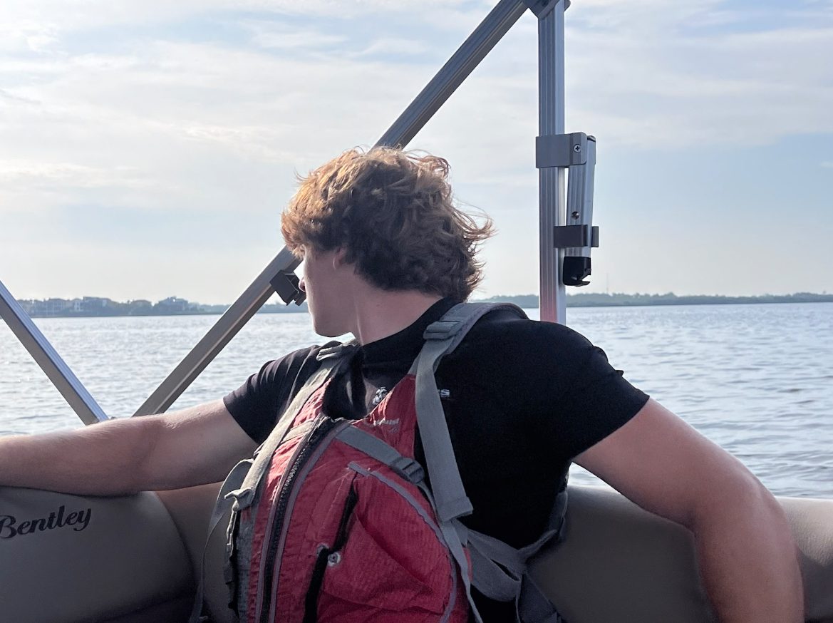 Matthew Madley on a boat looking out into the ocean to see if he could find any marine animals.