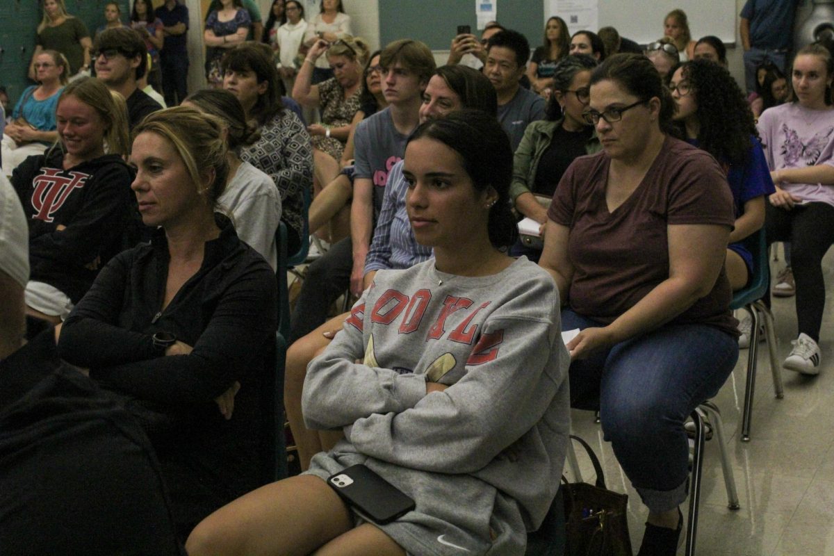 Senior Charles Millen listening to Mrs. Black explain information at College Applications Night.