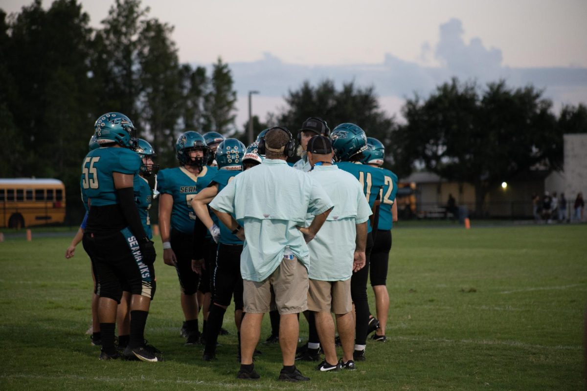 Sunlake football players surrounding the coaches during a short period of time between plays.