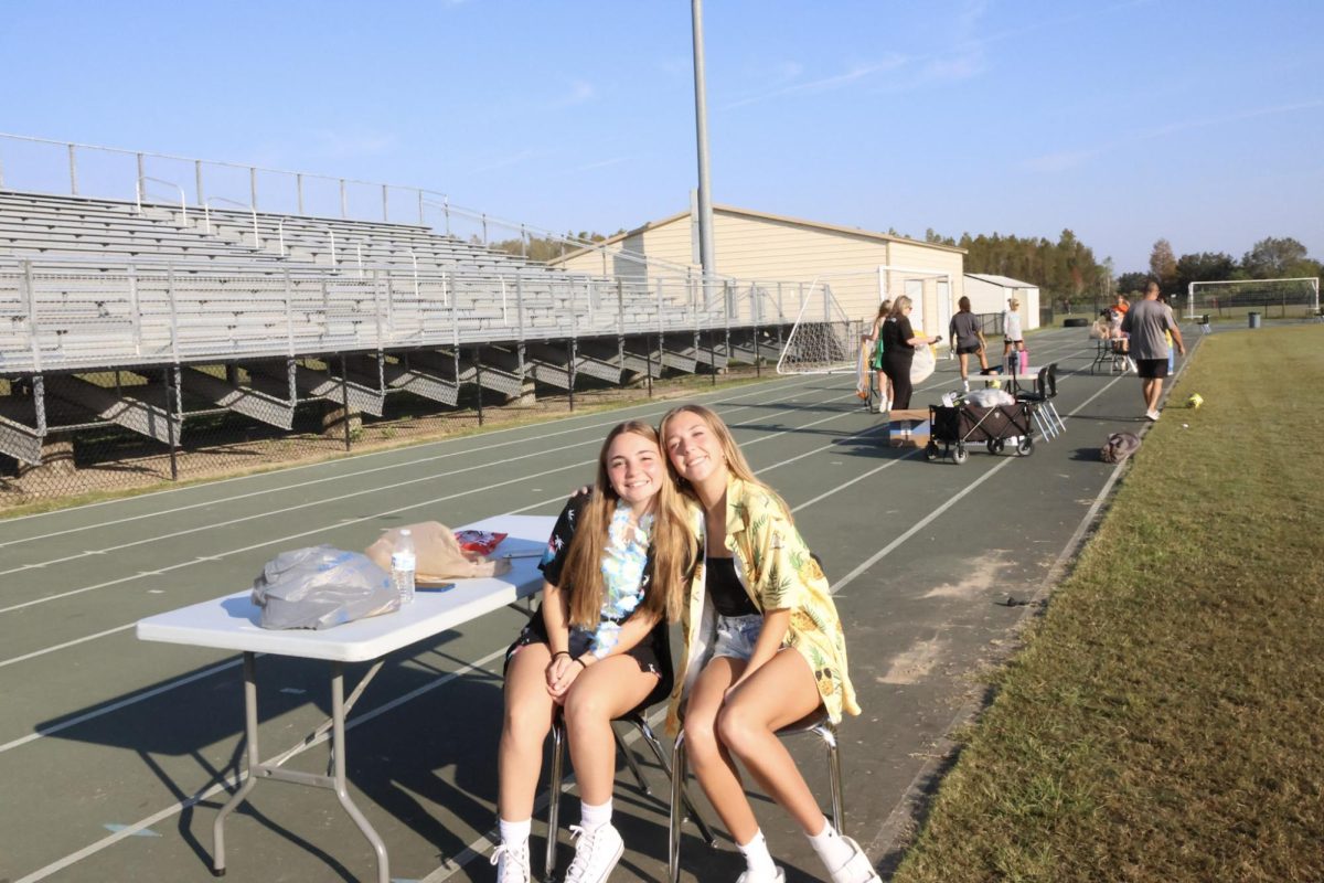 Sophomore Mara Crockett on the left volunteers with Mia Walter on the right at Trick or Treat around the track. They brighten up kids days by playing games with them and handing out candy in return. 