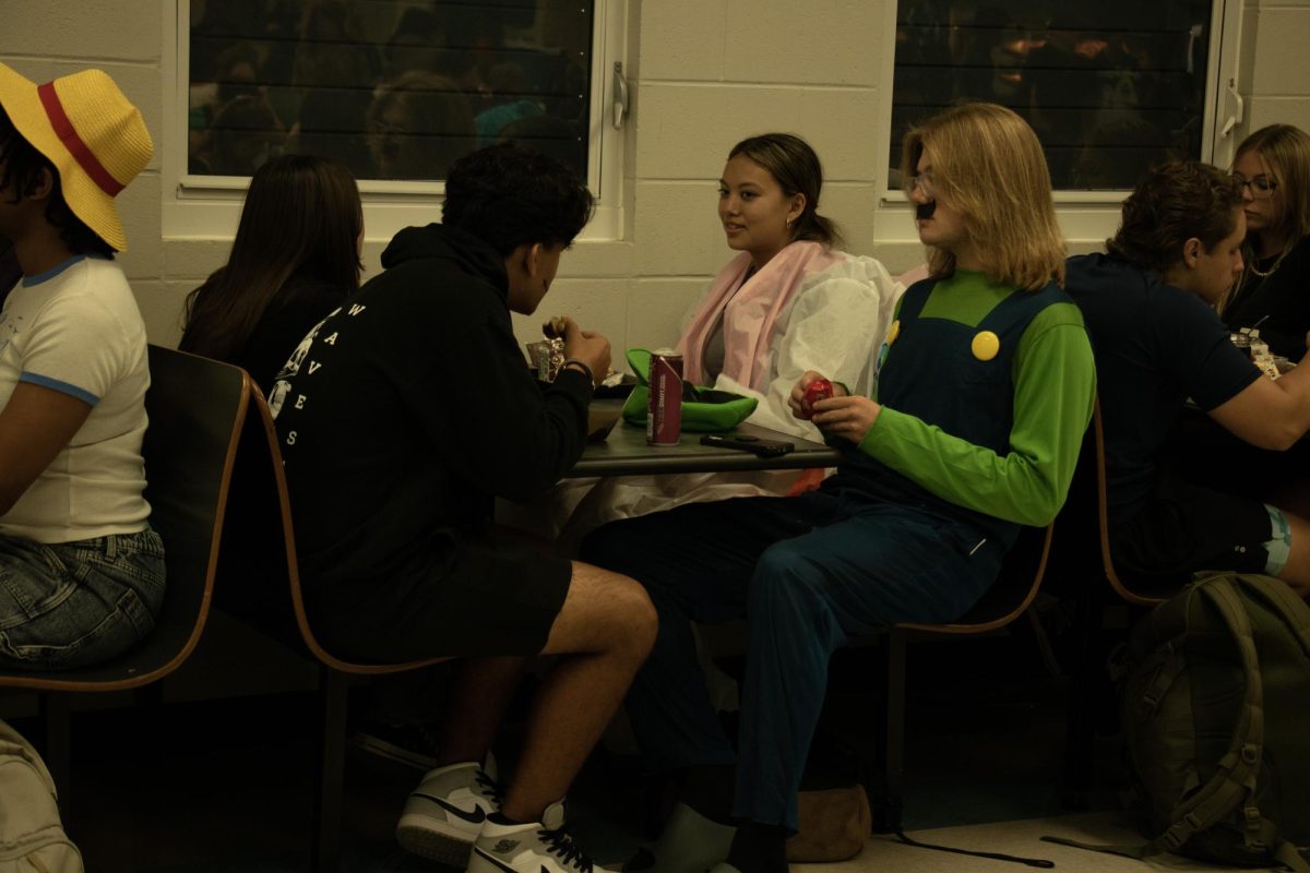 This is Joshwa Cote> he is seen sititng with his freinds at lunch eating and talking. He is dressed up as Luigi for Halloween dress up day.
Photo Credit: Hanna S. Trias