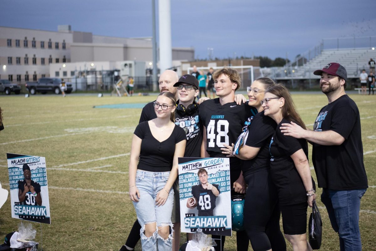 Matthew Gorden and his family taking photos together during Sunlake's senior night.