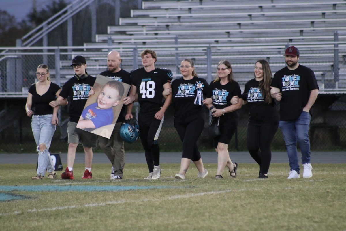 Matthew and his family walking down the field on senior night.