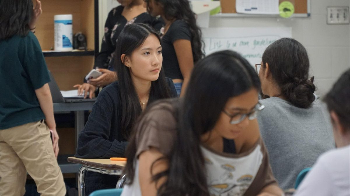 Jolynn Chen sitting among other HOSA members discussing what competitive events they plan on participating in this year.