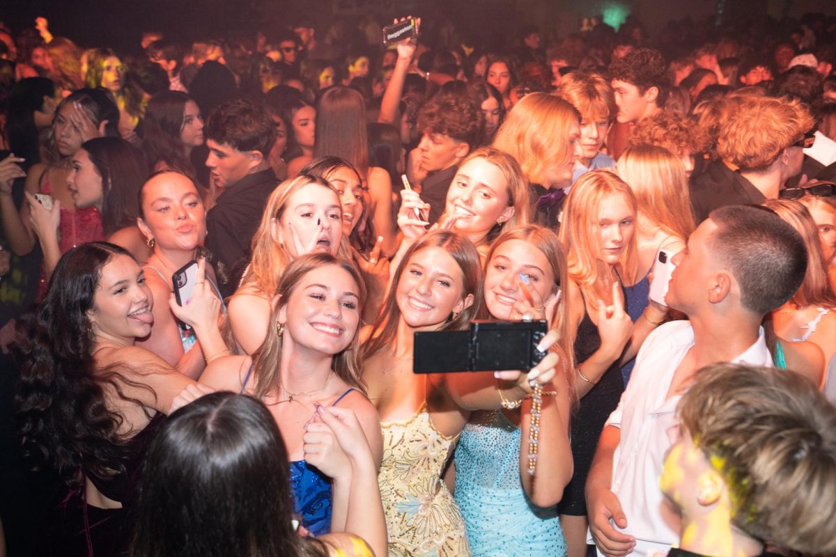 Sophomores Lily Hyatt ,Gemma Parker, and Kallie Scepkowski taking a picture on their digital camera at the Sunlake Homecoming Dance. 