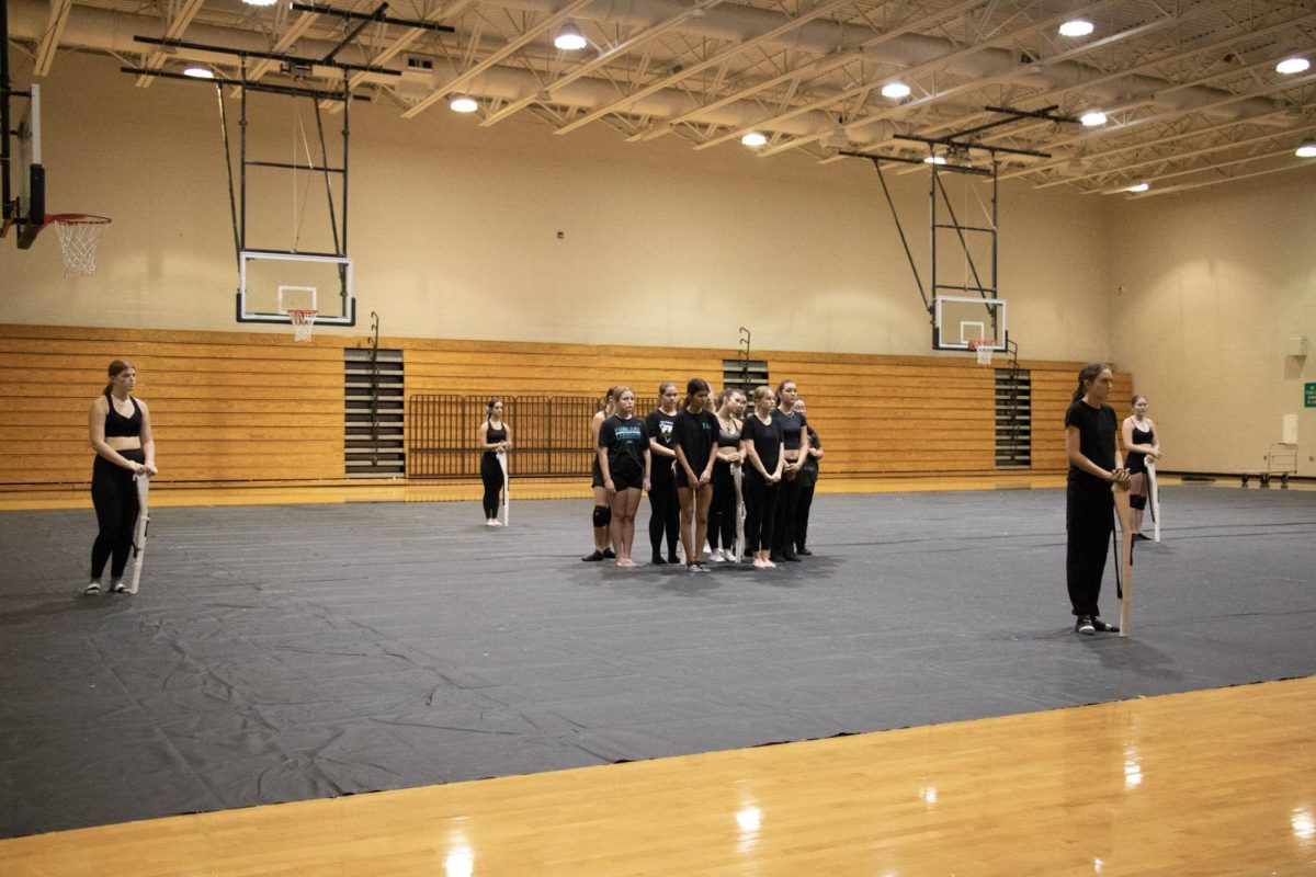 Laila and the rest of her color guard team figuring out spots for her winter guard performance. Laila is the girl in the blue bow. Laila said, "Wea re all very excited for our winter performance." and that they are working really hard.