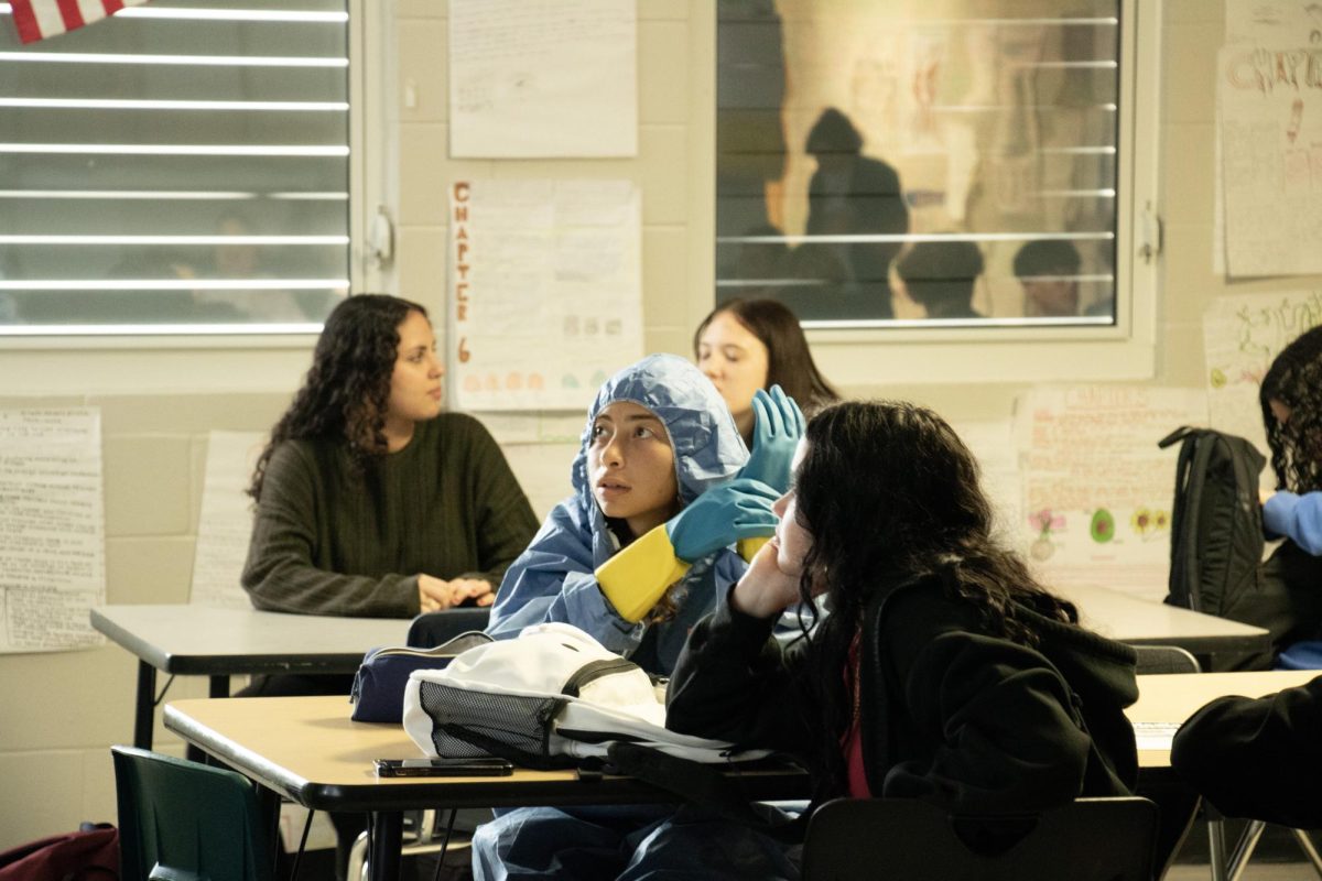 Jazleen Vega wearing a forensics protection gown during a presentation for the Great American Teach-In.
Week of 11/25-11/29