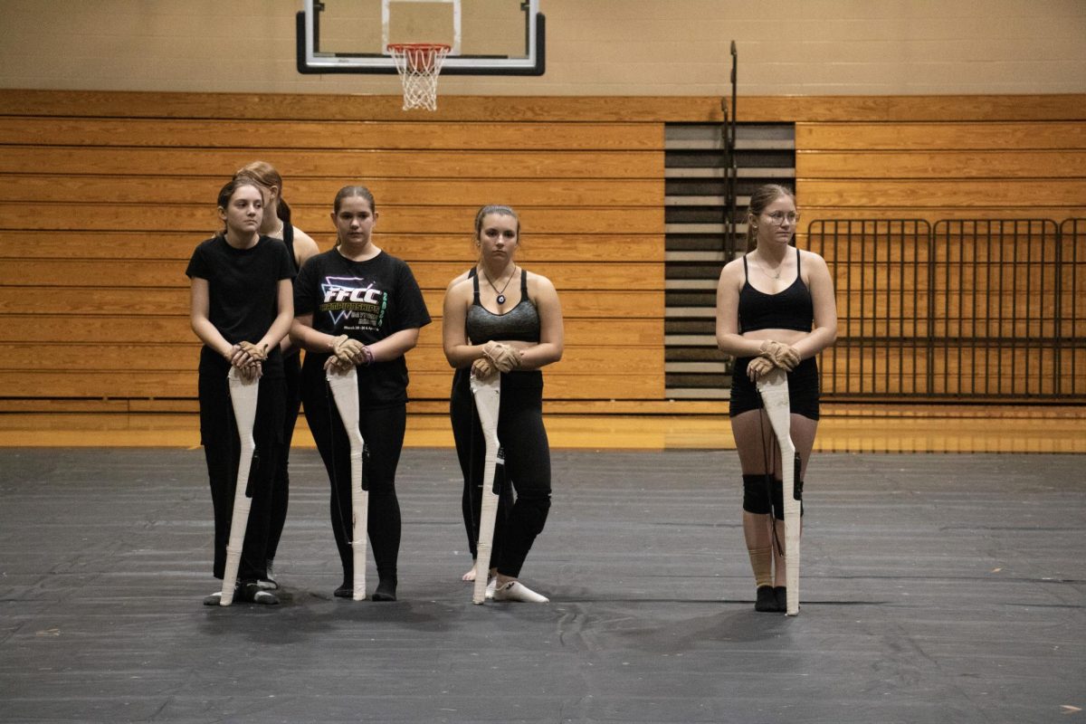 Standing in their positions for her winter guard performance are Lucy and a few members of her color guard squad. The girl with FFCC shirt is Lucy. "We are all looking forward to our winter performance," Lucy added, saying that they are putting in a lot of effort.