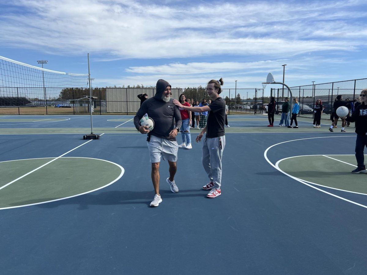 Coach Ricabal interacting with a student during his volleyball class.