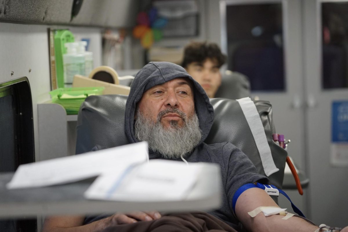 Coach Ricabal on the OneBlood bus donating blood.