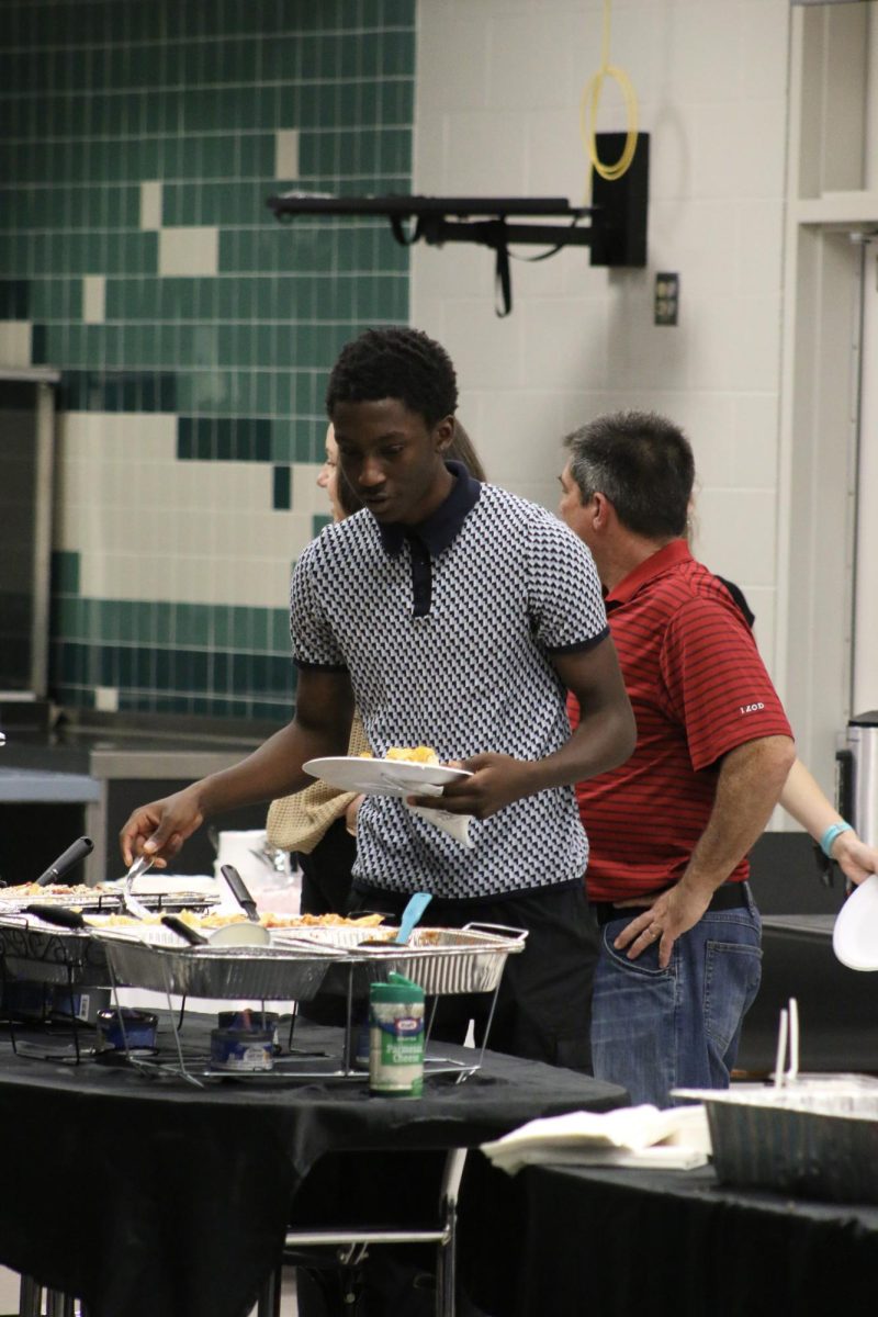 Quentin Minisee at the banquet grabbing his food. "had 4 plates myself." he stated. He enjoyed all the food.