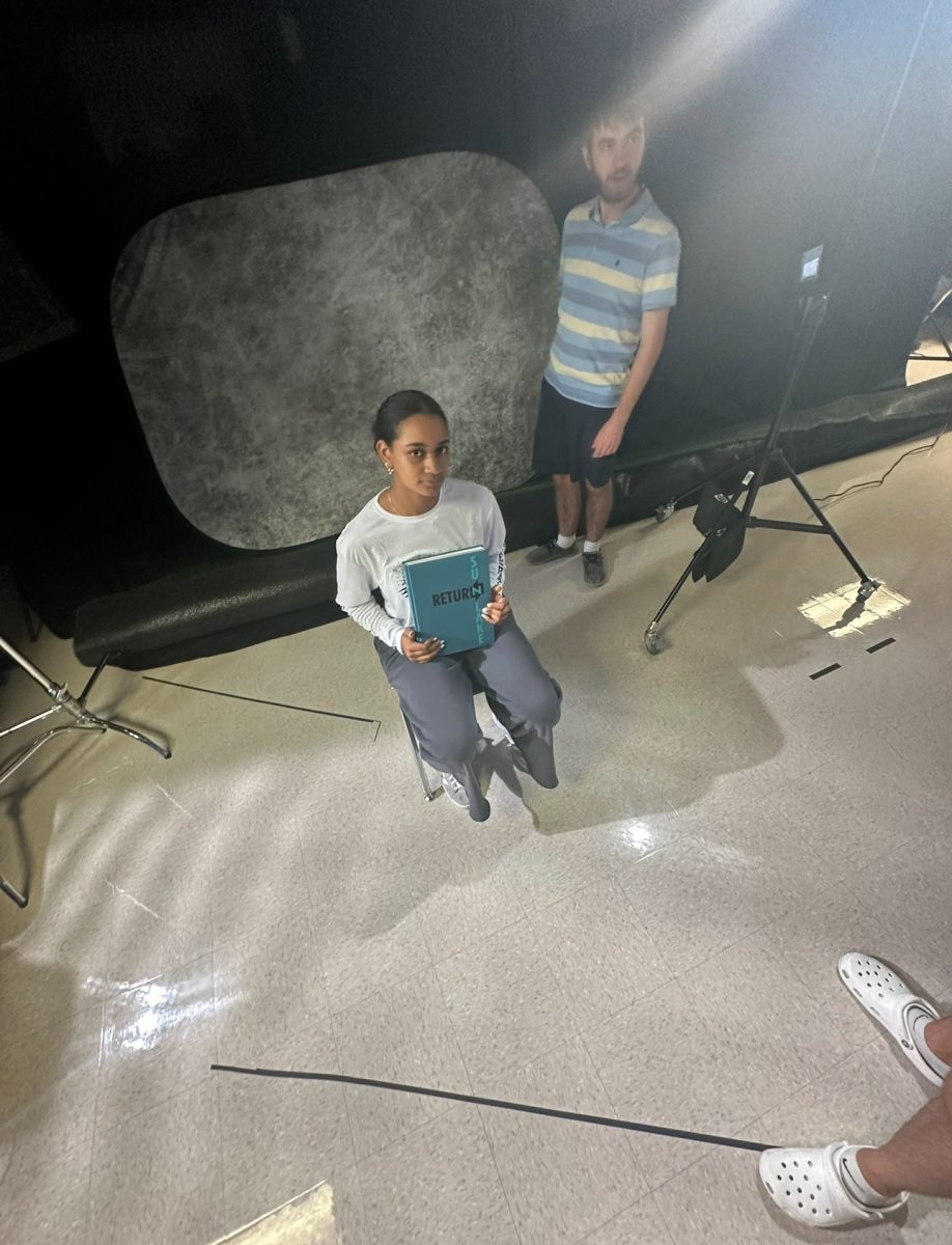 Senior Zayda Thomas getting ready to fil a Tiktok for Sunlake's yearbook Tiktok. Senior Daniel Crane is also helping set up the background and lighting.